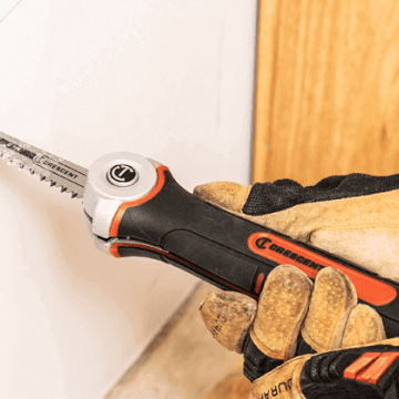 Man using a Crescent jab saw to cut out a spot of dry wall